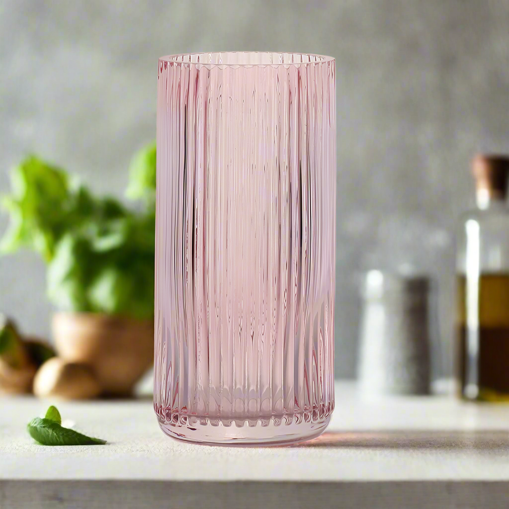 Pink ribbed glass vase on a white background
