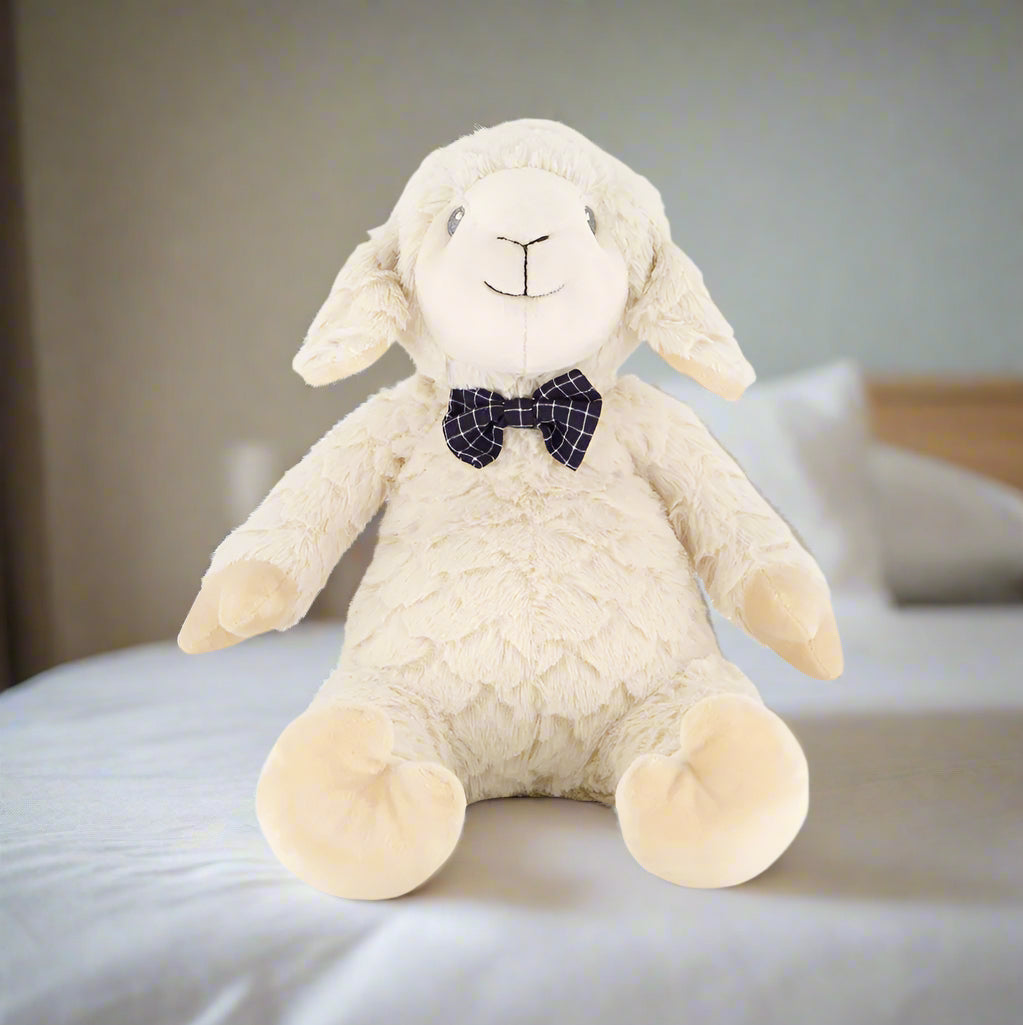 Plush toy sheep with a bow tie on a white background