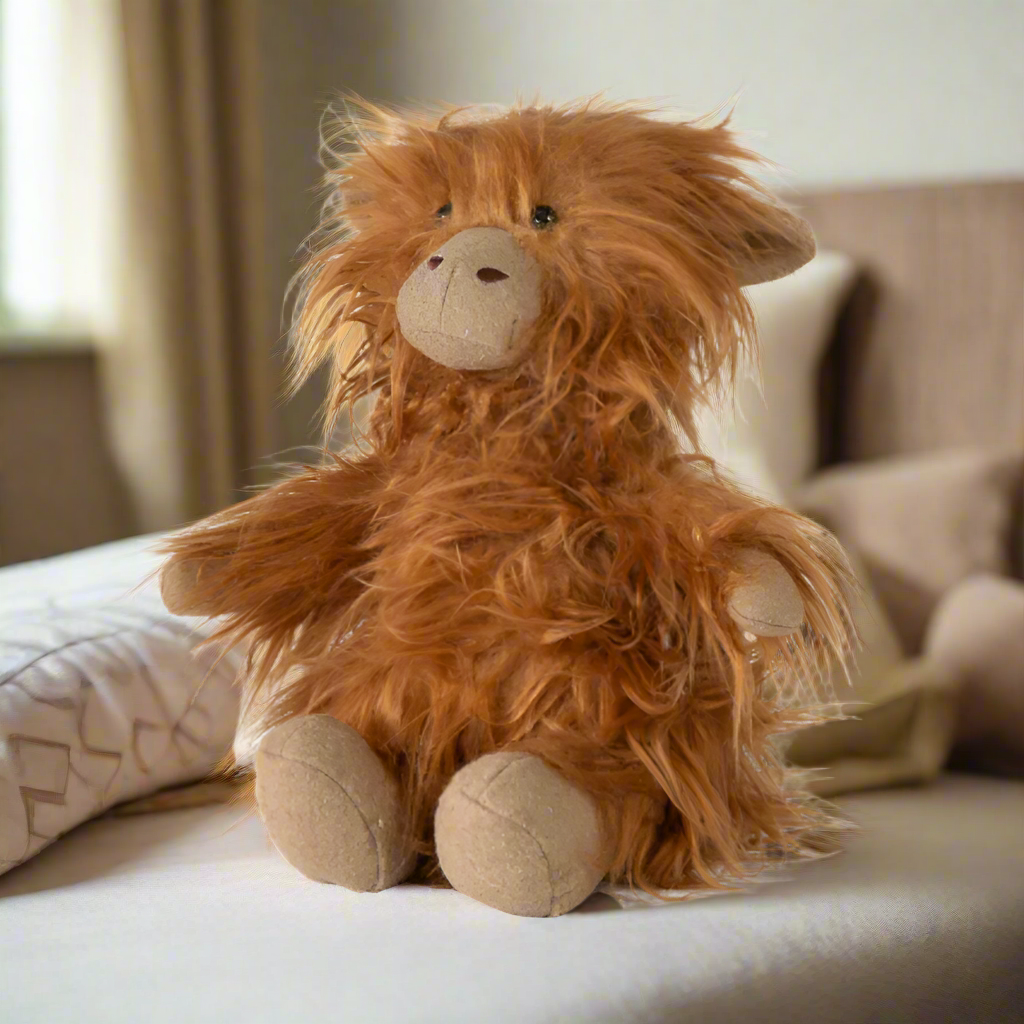 Plush toy resembling a Highland cow on a white background