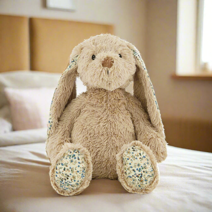 A beige plush bunny with patterned ears and feet, sitting upright.